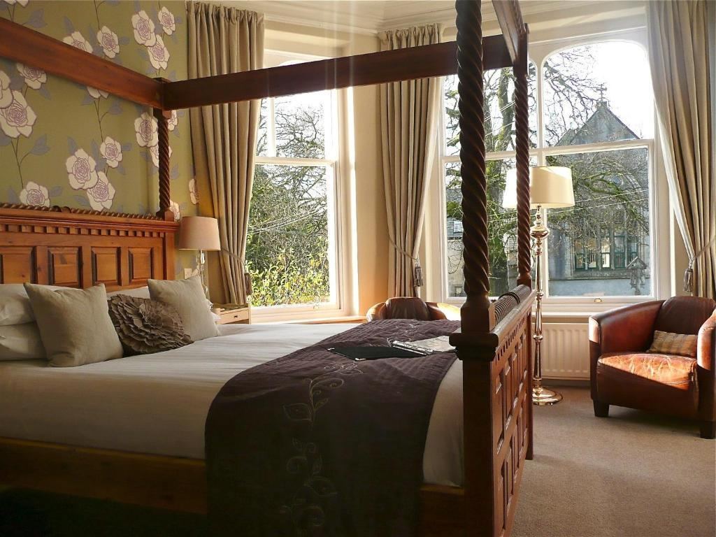 Four-poster bedroom at Rosemount Guest House with floral wallpaper and bay window